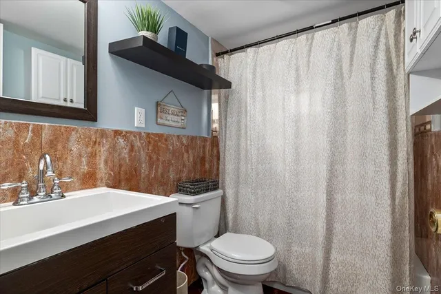 a bathroom with a sink a toilet and shower curtain