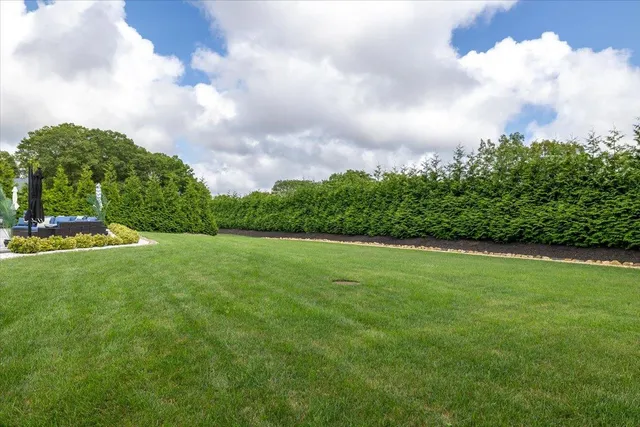 a view of a green field with wooden fence