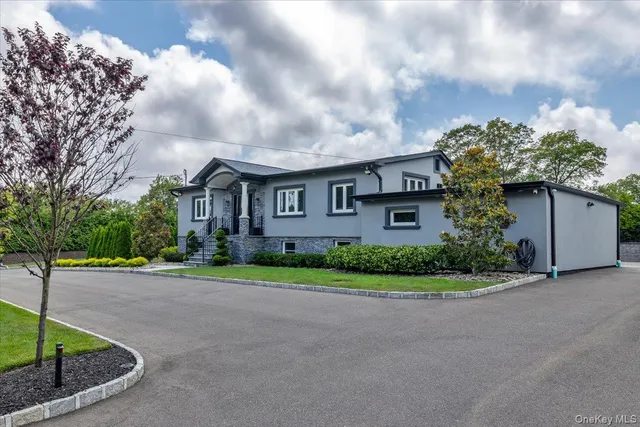 a view of a big brick house next to a yard with large trees