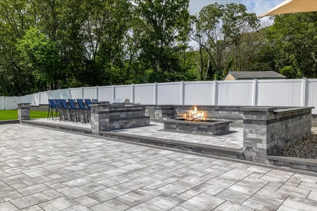 a view of a backyard with wooden fence and large trees