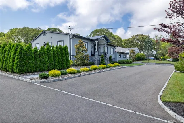 a view of a house with a yard and potted plants