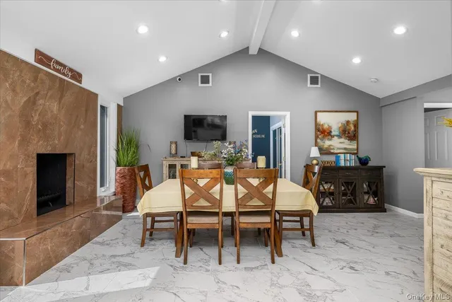 a dining room with furniture a fireplace and a flat screen tv