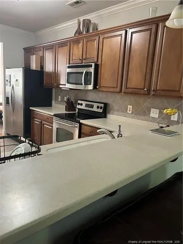 a kitchen with stainless steel appliances a sink stove and microwave