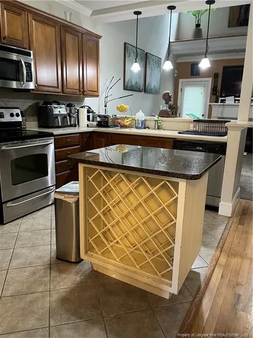 a kitchen with kitchen island granite countertop a sink cabinets and stainless steel appliances