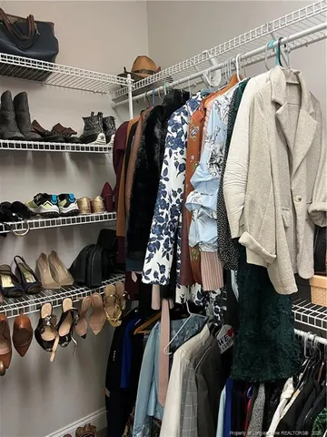 a view of walk in closet with clothes and shoes