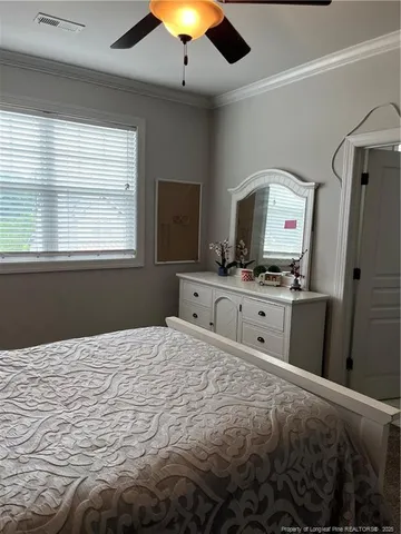 a large bedroom with a bed and a flat tv screen on dresser