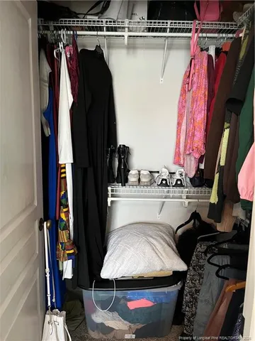 a view of walk in closet with clothes and shoes