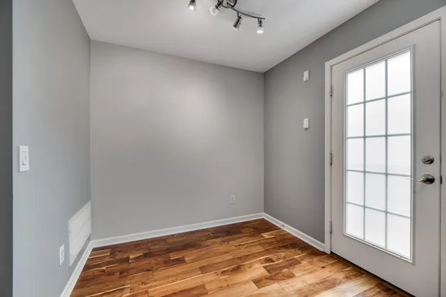 an empty room with wooden floor and windows