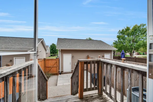 a view of a house with wooden deck and furniture