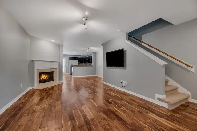 a view of empty room with a fireplace and wooden floor