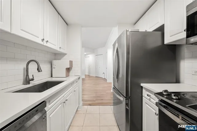 a kitchen with stainless steel appliances a refrigerator sink and stove