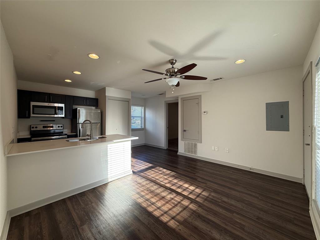2106 Bennett Avenue, Unit 106 Dallas, TX 75206 - Photo 3 of 14 a large kitchen with stainless steel appliances a large counter top a stove a sink and a refrigerator