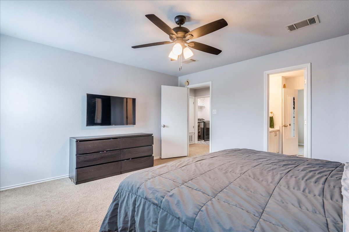 148 Buttercup Way Kyle, TX 78640 - Photo 14 of 33 Bedroom with light colored carpet, ceiling fan, and ensuite bathroom