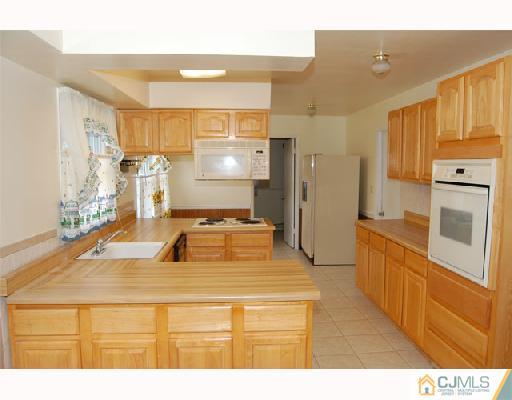 8 Tamarack Road Somerset, NJ 08873 - Photo 2 of 8 a kitchen with stainless steel appliances kitchen island granite countertop a refrigerator and a stove top oven