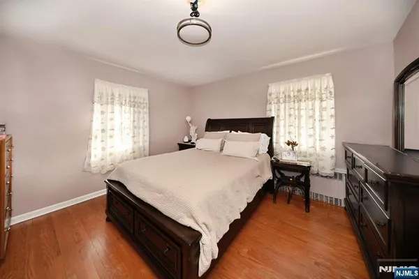 a bedroom with a bed and a flat tv screen on the dresser