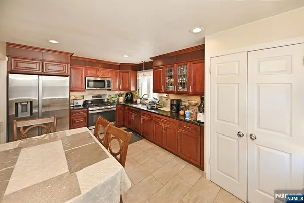 a kitchen with stainless steel appliances granite countertop a refrigerator oven a sink dishwasher and cabinets with wooden floor