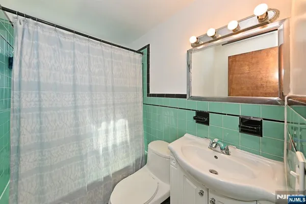 a bathroom with a sink mirror and toilet