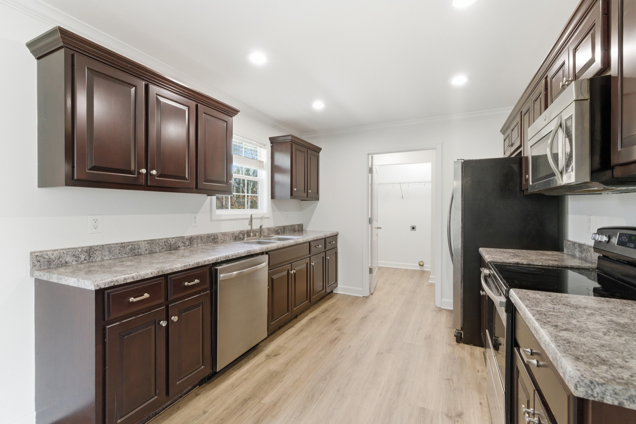 217 Spring Breeze Drive Smithville, TN 37166 - Photo 11 of 34 a kitchen with stainless steel appliances granite countertop wooden cabinets a stove top oven a sink and dishwasher
