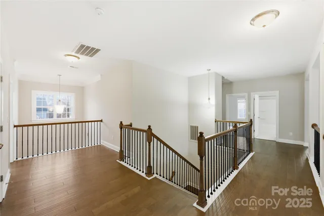 a view of a hallway with wooden floor and windows