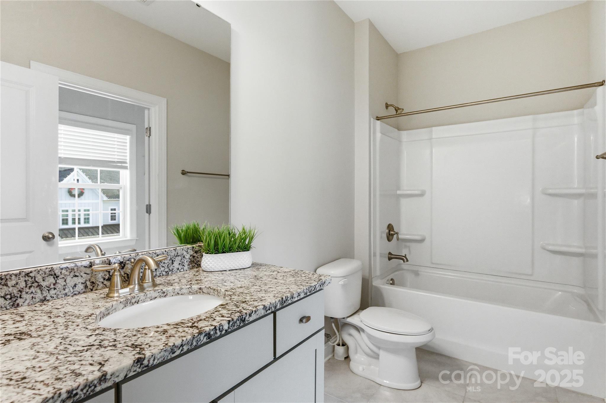 194 Forsythia Lane Tega Cay, SC 29708 - Photo 29 of 31 a bathroom with a granite countertop sink toilet mirror and shower