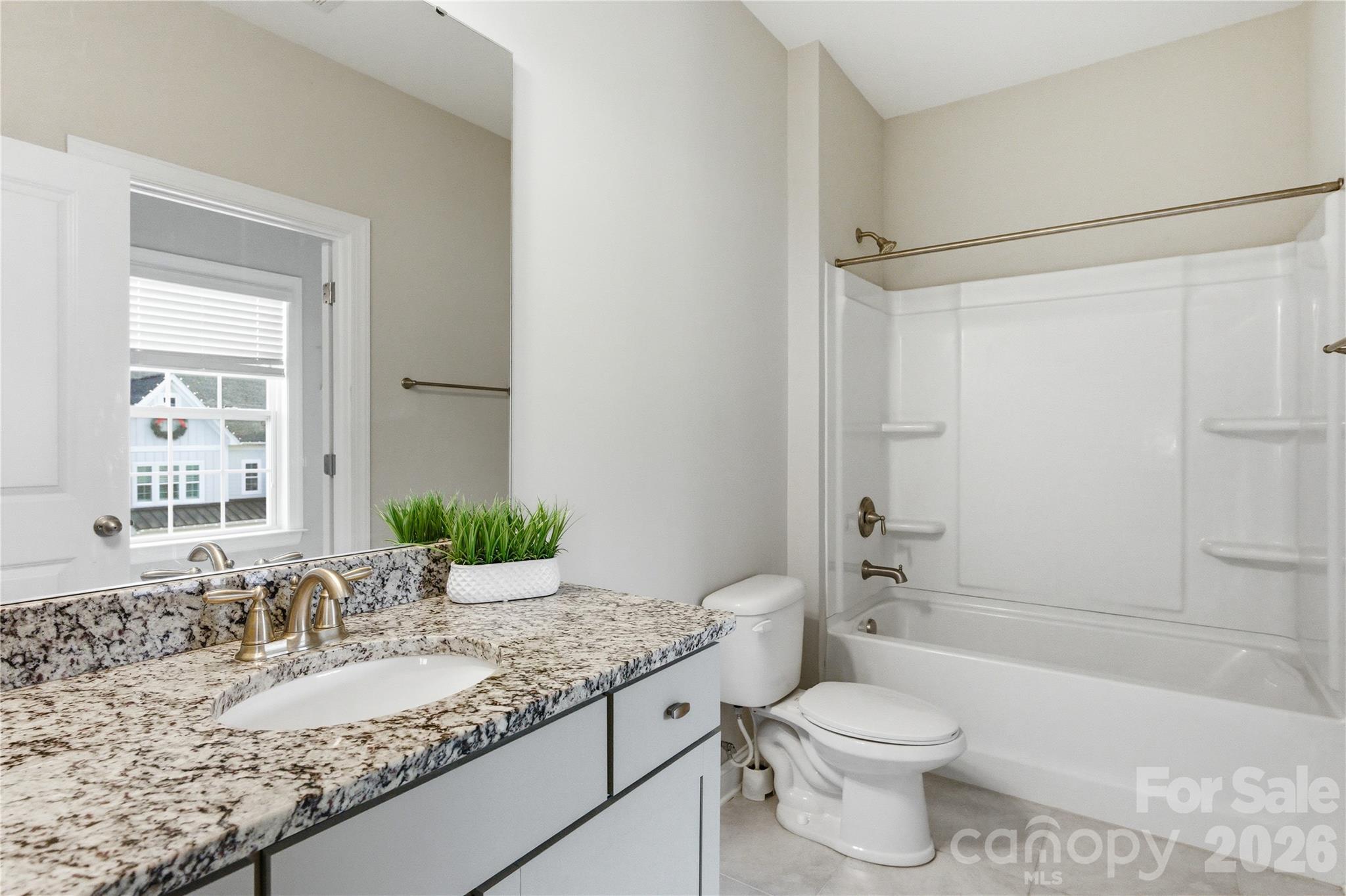 194 Forsythia Lane Tega Cay, SC 29708 - Photo 29 of 36 a bathroom with a granite countertop sink toilet mirror and shower
