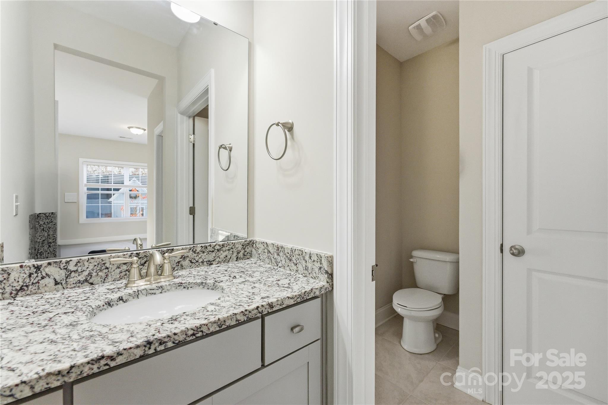 194 Forsythia Lane Tega Cay, SC 29708 - Photo 31 of 31 a bathroom with a granite countertop sink a toilet and a shower