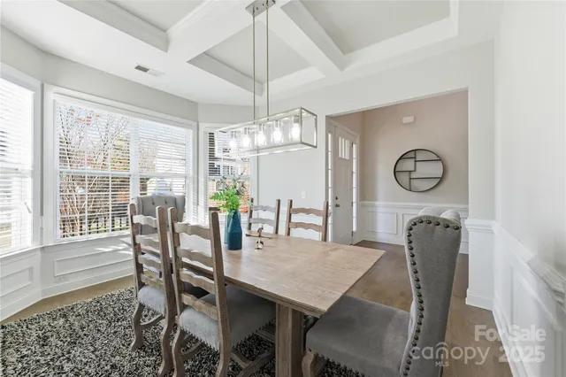 a dining room with furniture a chandelier and window