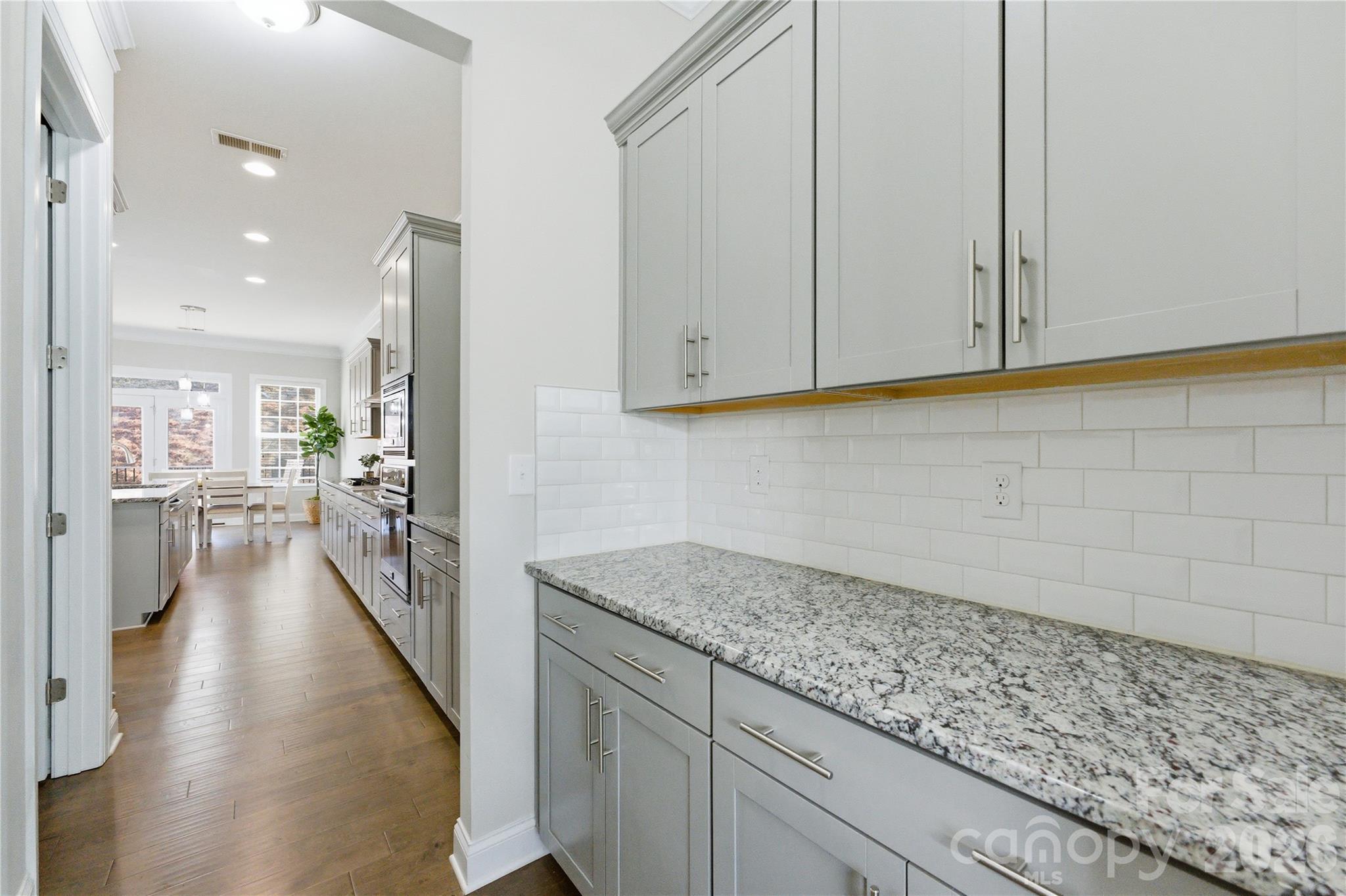 194 Forsythia Lane Tega Cay, SC 29708 - Photo 9 of 37 a view of a kitchen with kitchen island white cabinets and stainless steel appliances