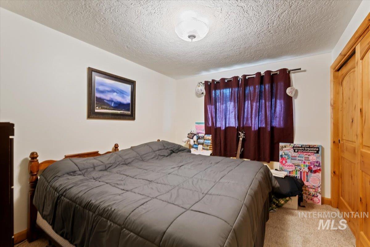 11650 Columbia Road Boise, ID 83709 - Photo 12 of 32 Carpeted bedroom featuring a textured ceiling and baseboards