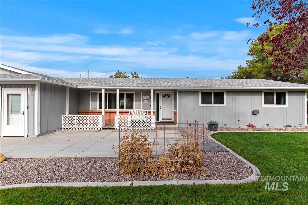 11650 Columbia Road Boise, ID 83709 - Photo 3 of 32 Ranch-style home with a shingled roof, a front yard, and a porch