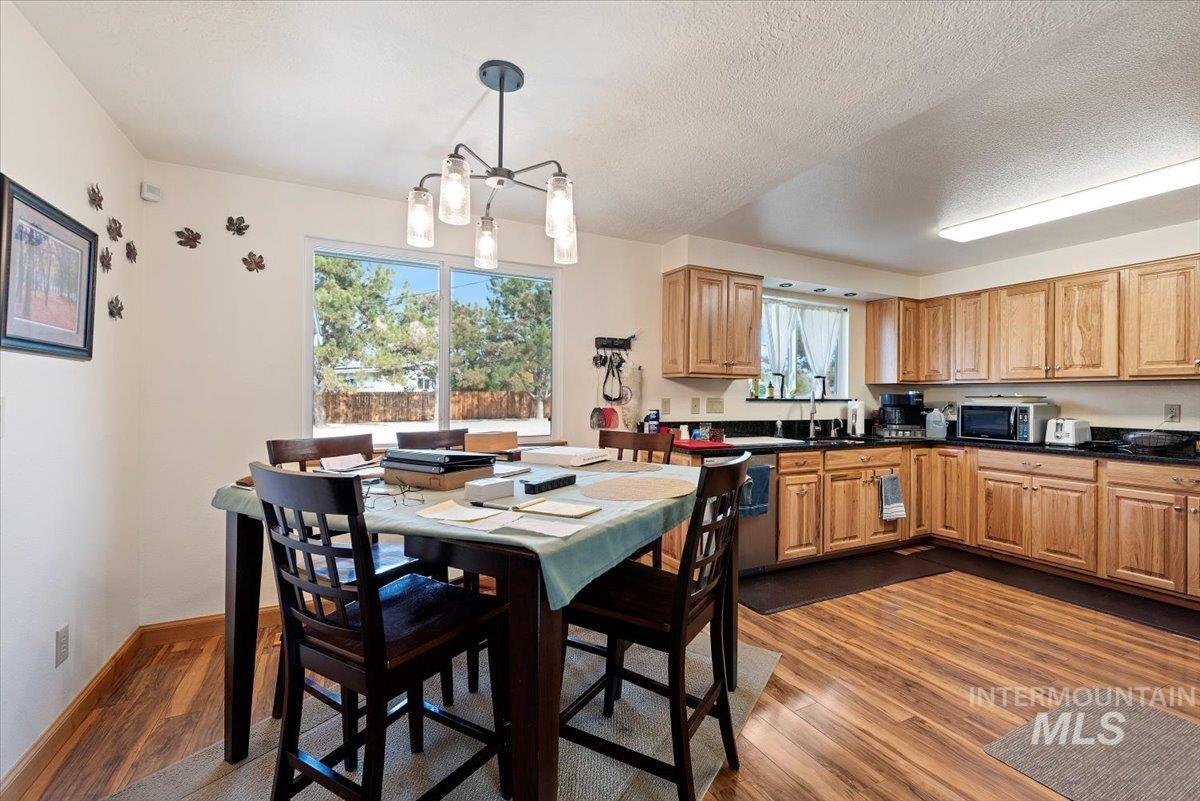 11650 Columbia Road Boise, ID 83709 - Photo 9 of 32 Kitchen featuring dark wood-style flooring, hanging light fixtures, appliances with stainless steel finishes, a textured ceiling, and a chandelier