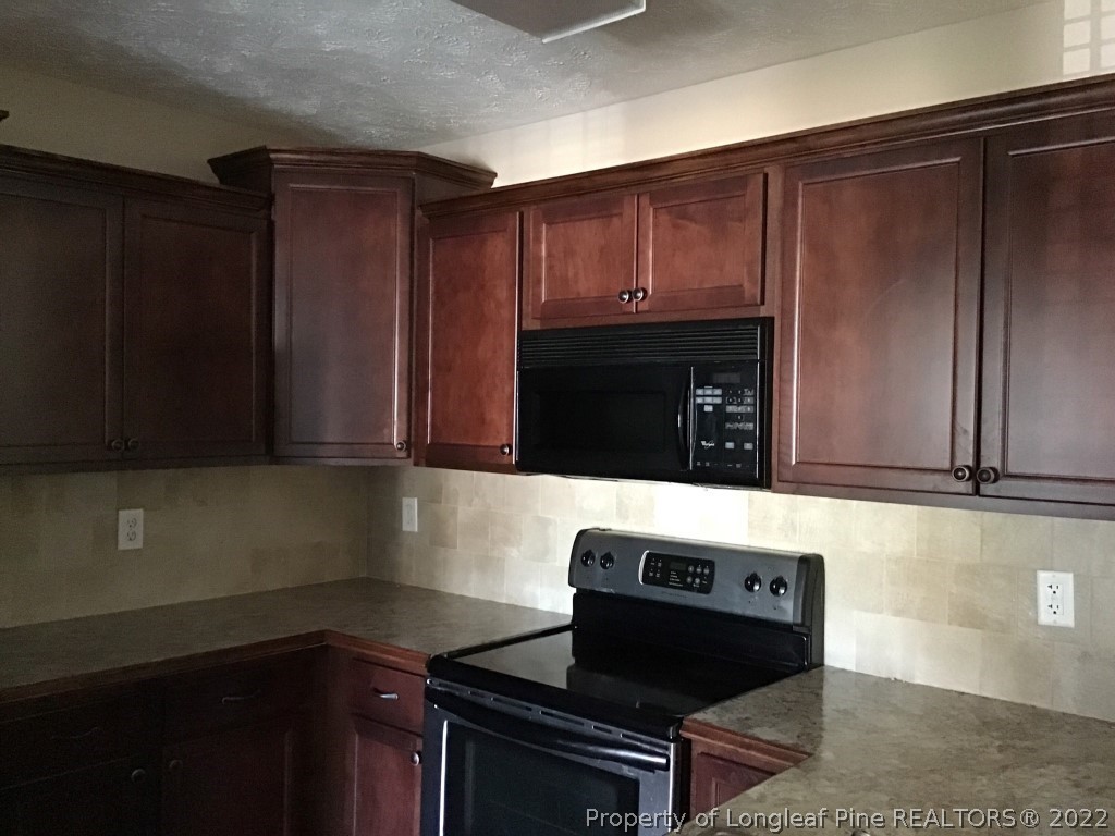 1913-4 Sardonyx Road Fayetteville, NC 28303 - Photo 6 of 12 a kitchen with wooden cabinets and a stove top oven