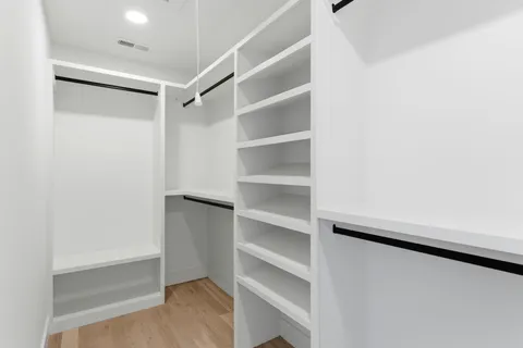 a view of walk in closet with empty racks