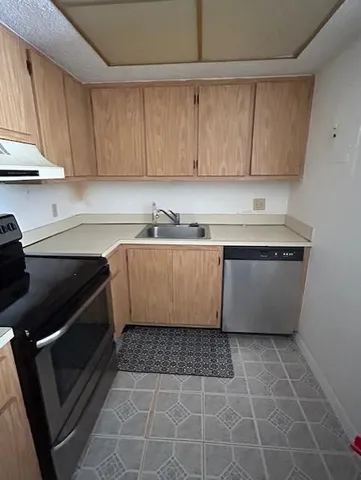 a kitchen with a sink a stove and cabinets