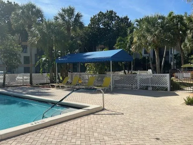 a view of a patio with a table and chairs under an umbrella