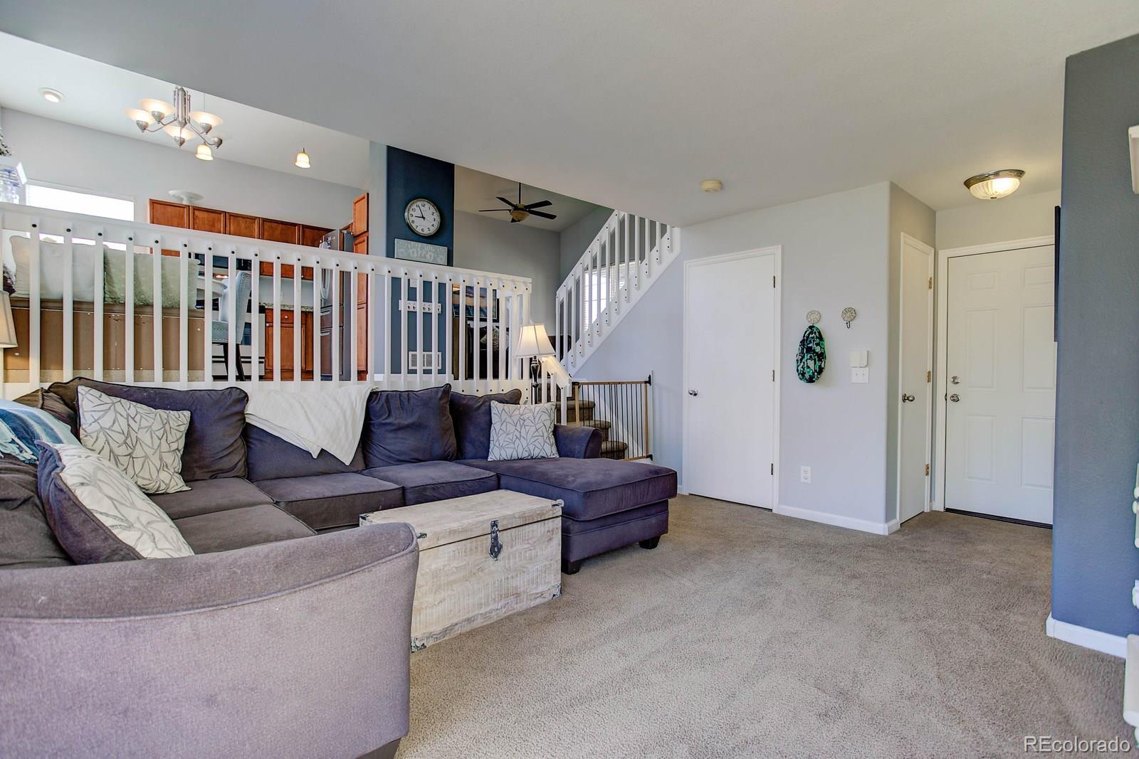 9847 Sydney Lane Highlands Ranch, CO 80130 - Photo 14 of 32 a living room with furniture stairs and a ceiling fan
