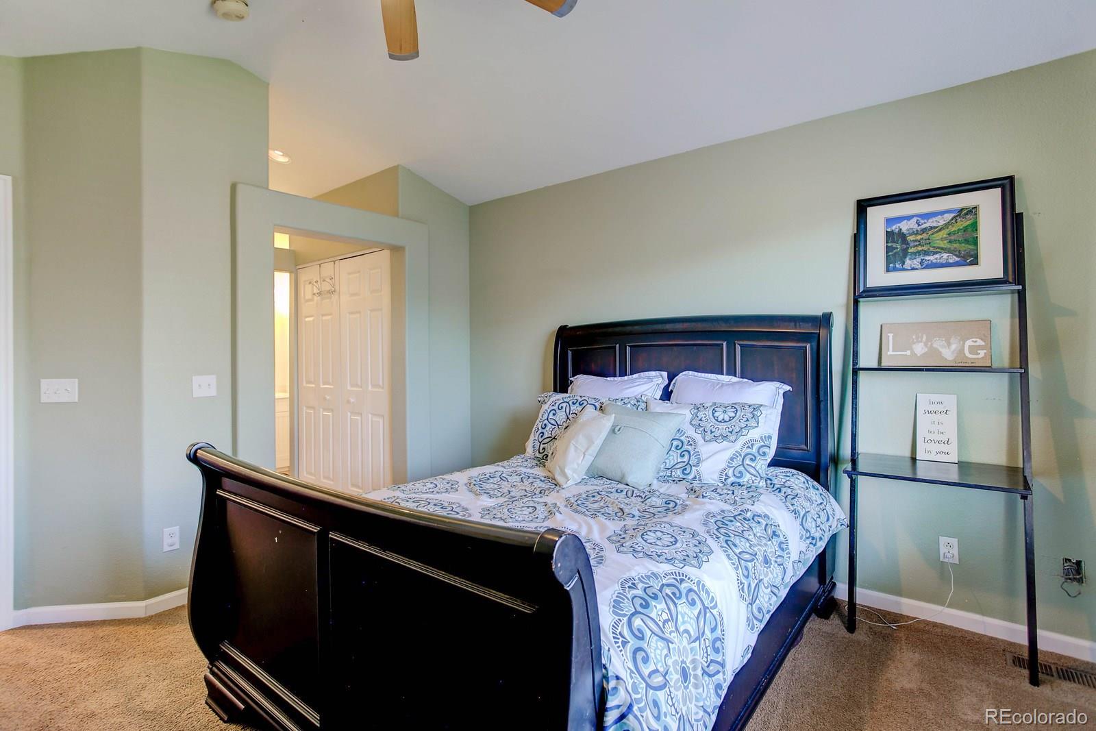9847 Sydney Lane Highlands Ranch, CO 80130 - Photo 18 of 32 a bed sitting in a bedroom next to a cabinet