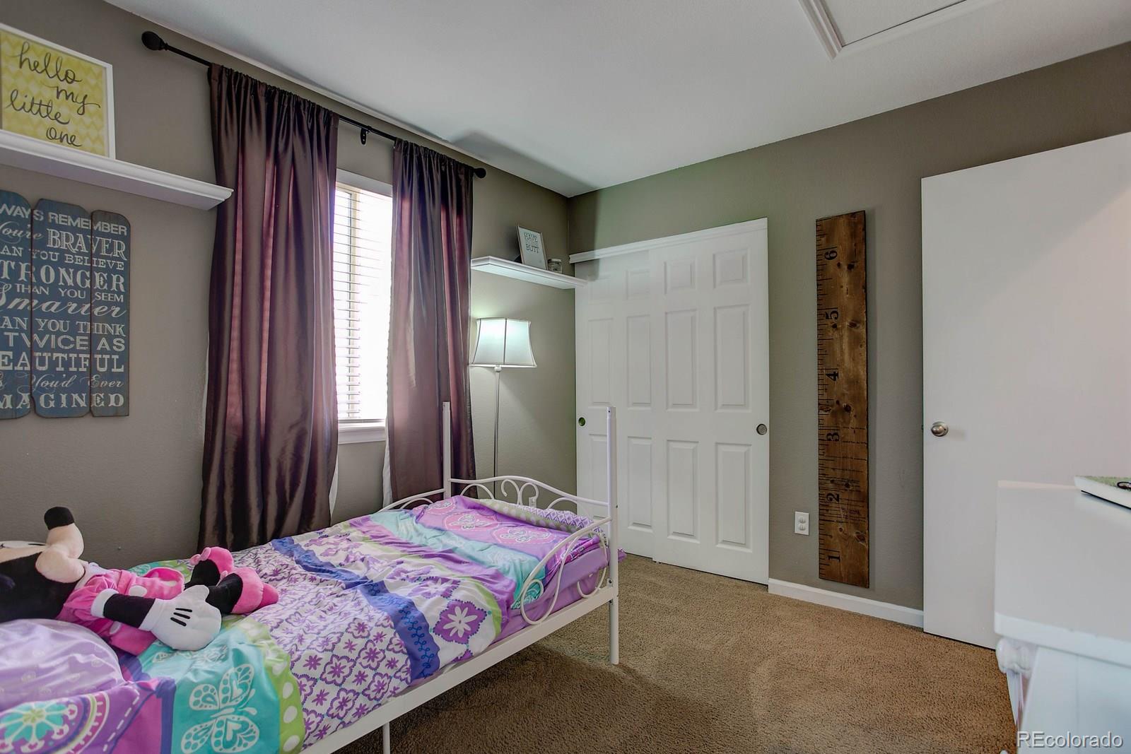 9847 Sydney Lane Highlands Ranch, CO 80130 - Photo 22 of 32 a bedroom with a bed dresser and a window