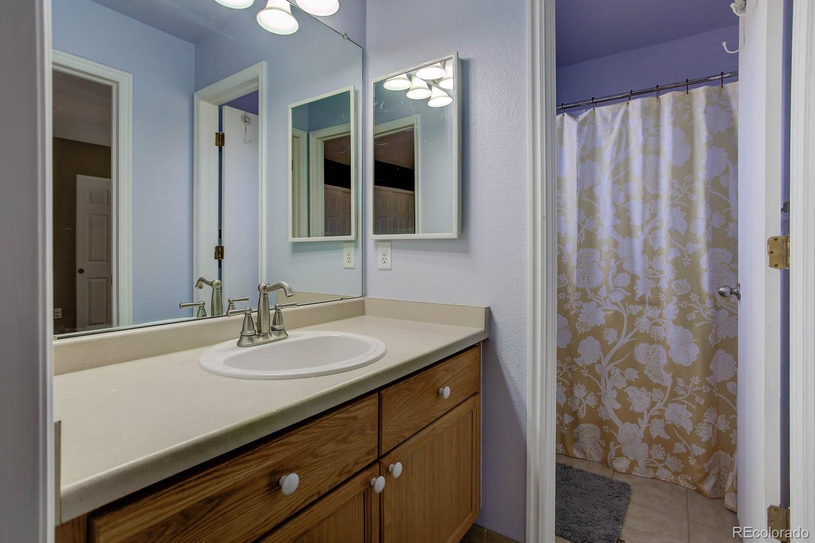 9847 Sydney Lane Highlands Ranch, CO 80130 - Photo 23 of 32 a bathroom with a granite countertop sink and a mirror