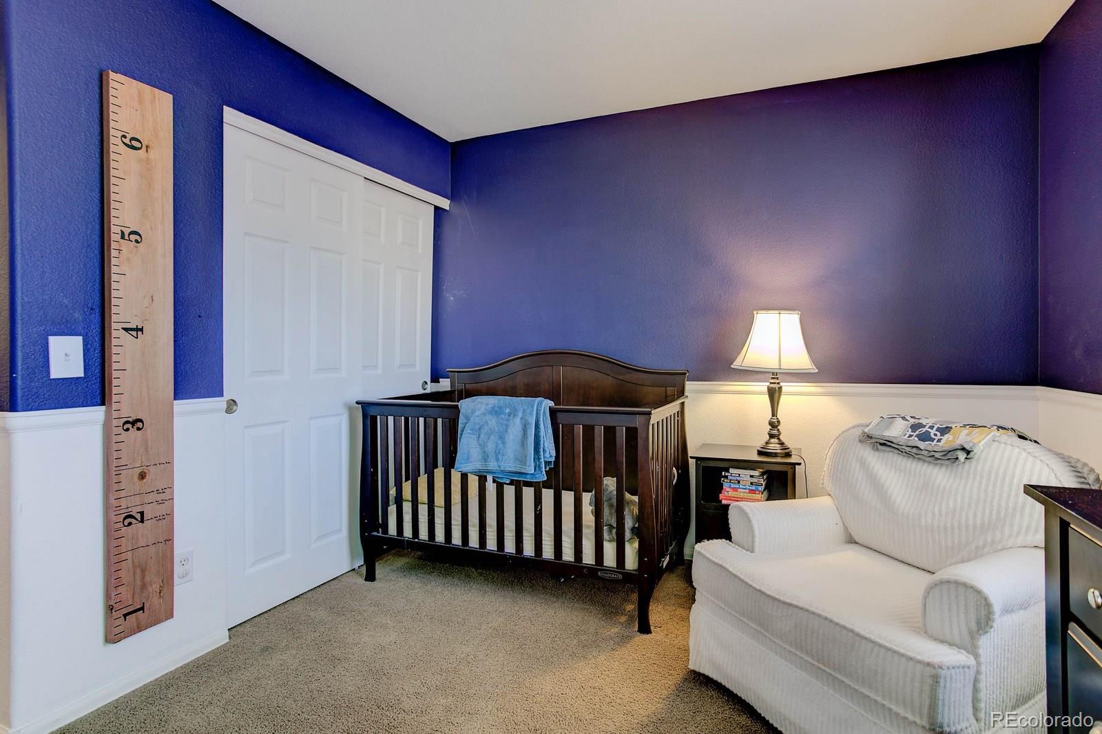 9847 Sydney Lane Highlands Ranch, CO 80130 - Photo 24 of 32 a bedroom with furniture and a lamp