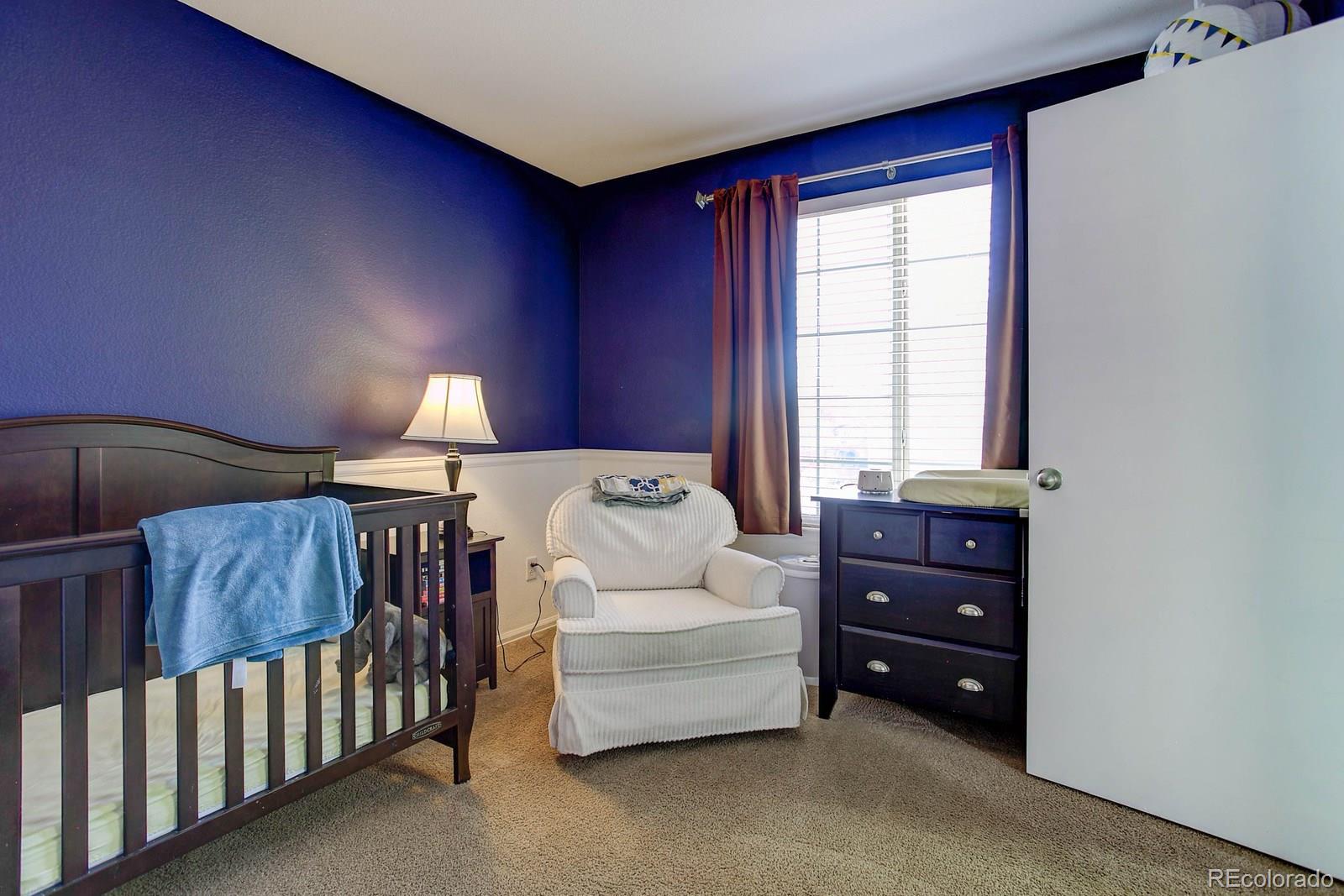 9847 Sydney Lane Highlands Ranch, CO 80130 - Photo 25 of 32 a bedroom with a bed and window
