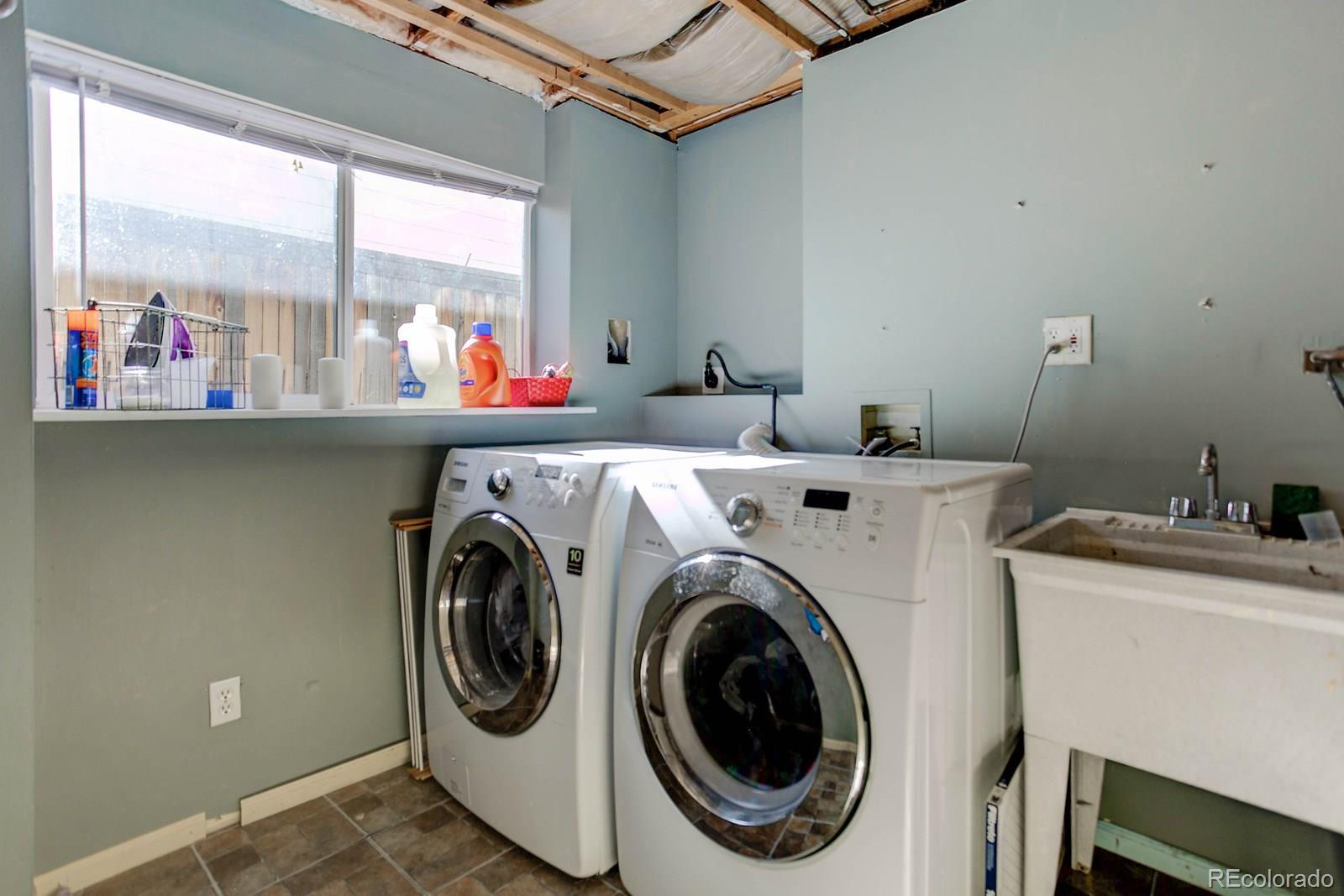 9847 Sydney Lane Highlands Ranch, CO 80130 - Photo 29 of 32 a utility room with dryer washer and a floor to ceiling window