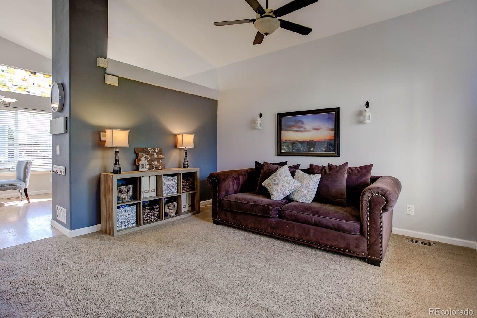 9847 Sydney Lane Highlands Ranch, CO 80130 - Photo 4 of 32 a living room with furniture and a flat screen tv