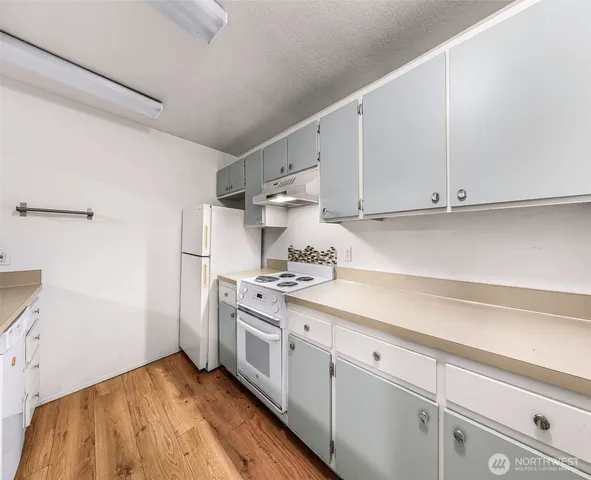 a kitchen with white cabinets and white appliances