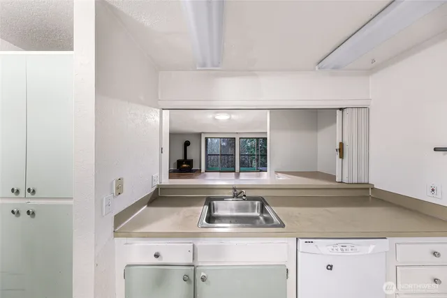 a view with granite countertop a sink and dishwasher cabinets with wooden floor