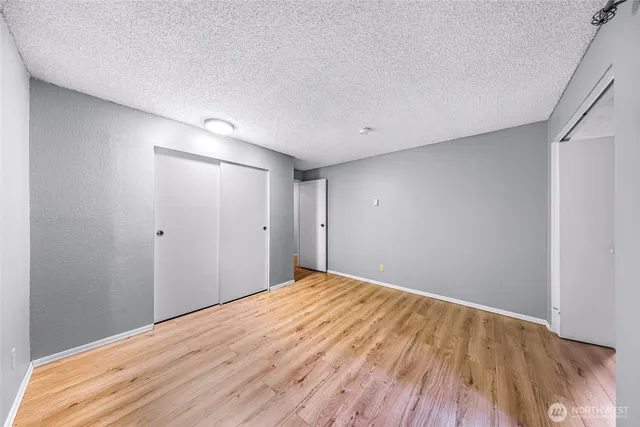 a view of empty room with wooden floor and floor to ceiling window