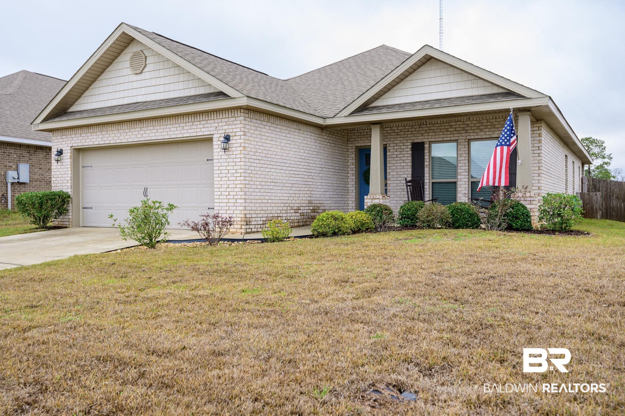 31751 Kestrel Loop Daphne, AL 36527 - Photo 2 of 21 View of front of property featuring a shingled roof, a garage, covered porch, and brick siding