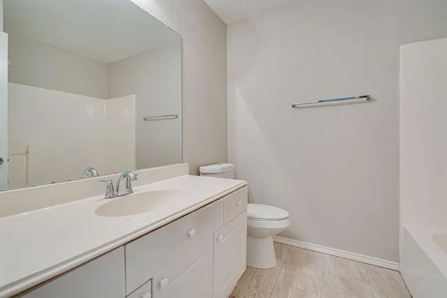 an empty room with a window and a ceiling fan