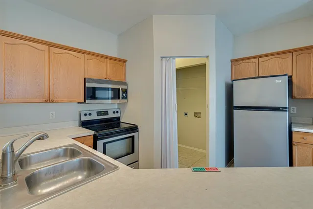 a kitchen with a refrigerator sink and cabinets