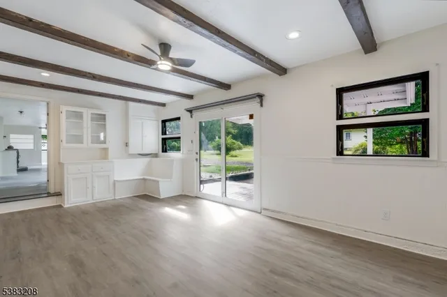 a view of a big room with wooden floor and windows